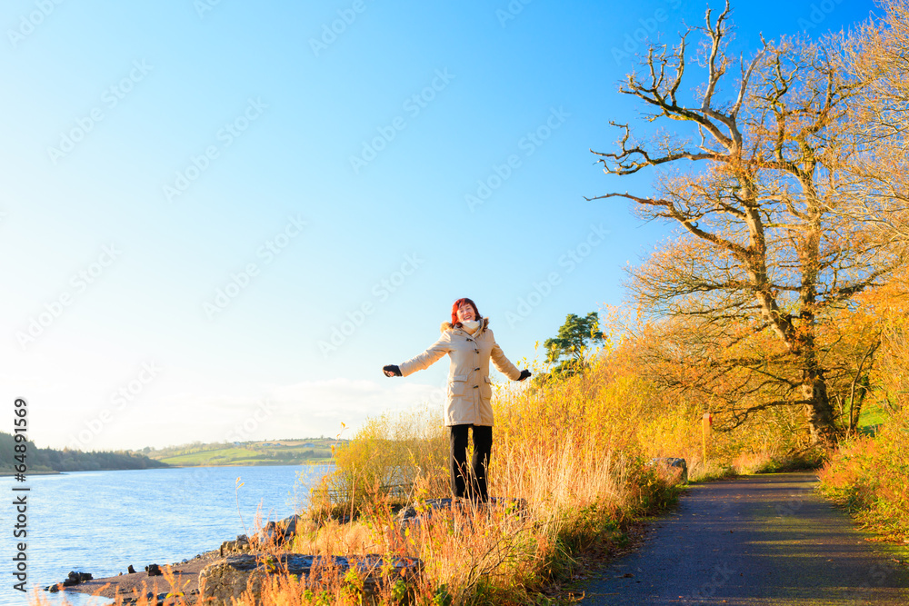 Obraz premium Autumn, Woman walking relaxing at the river. Co.Cork, Ireland.