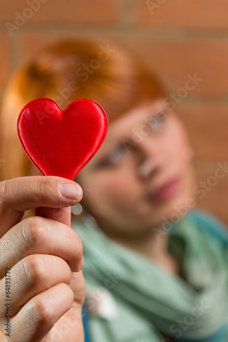 Girl holding heart. Heart is in focus.