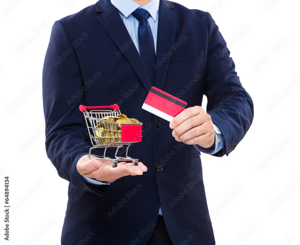Businessman holding credit card and shopping cart with coin Businessman holding credit card and shopping cart with coin