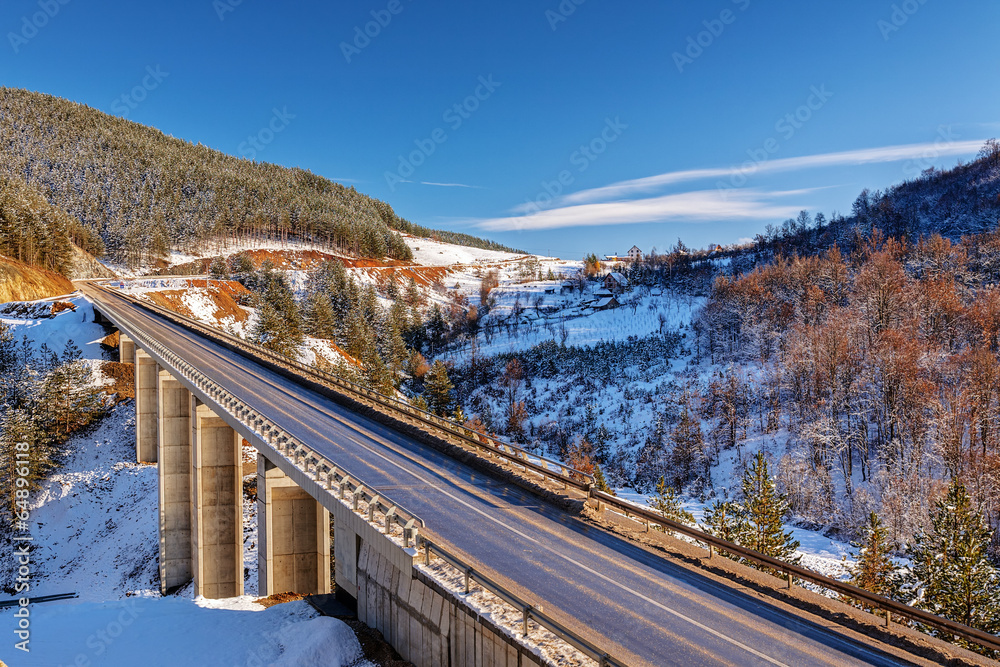mountain bridge in winter with snow and blue sky