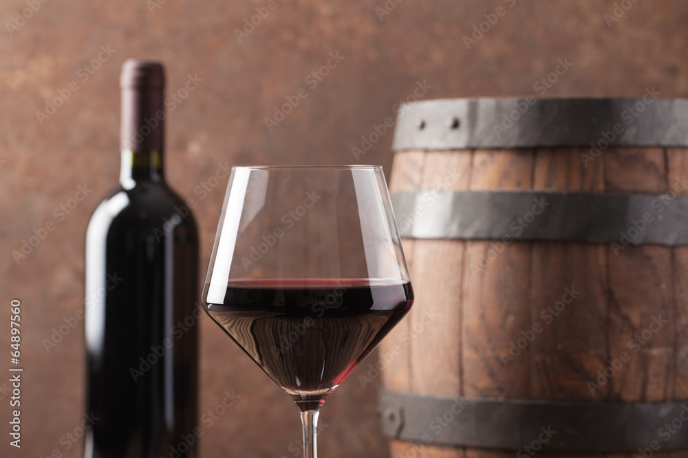 Glass with red wine and old barrel.
