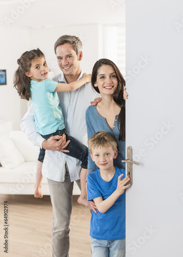 Family standing at front door to invite people at home