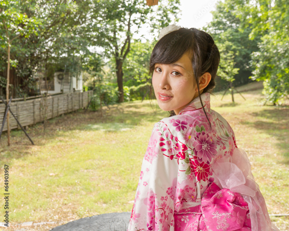 Asian woman wearing a kimono in Japanese garden Asian woman wearing a kimono in Japanese garden