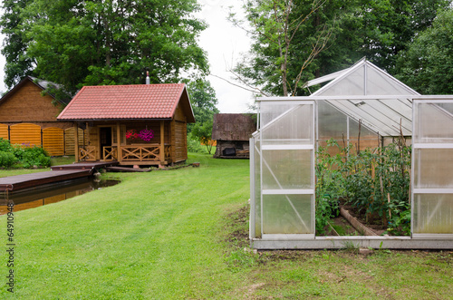 greenhouse and traditional wooden bath in village