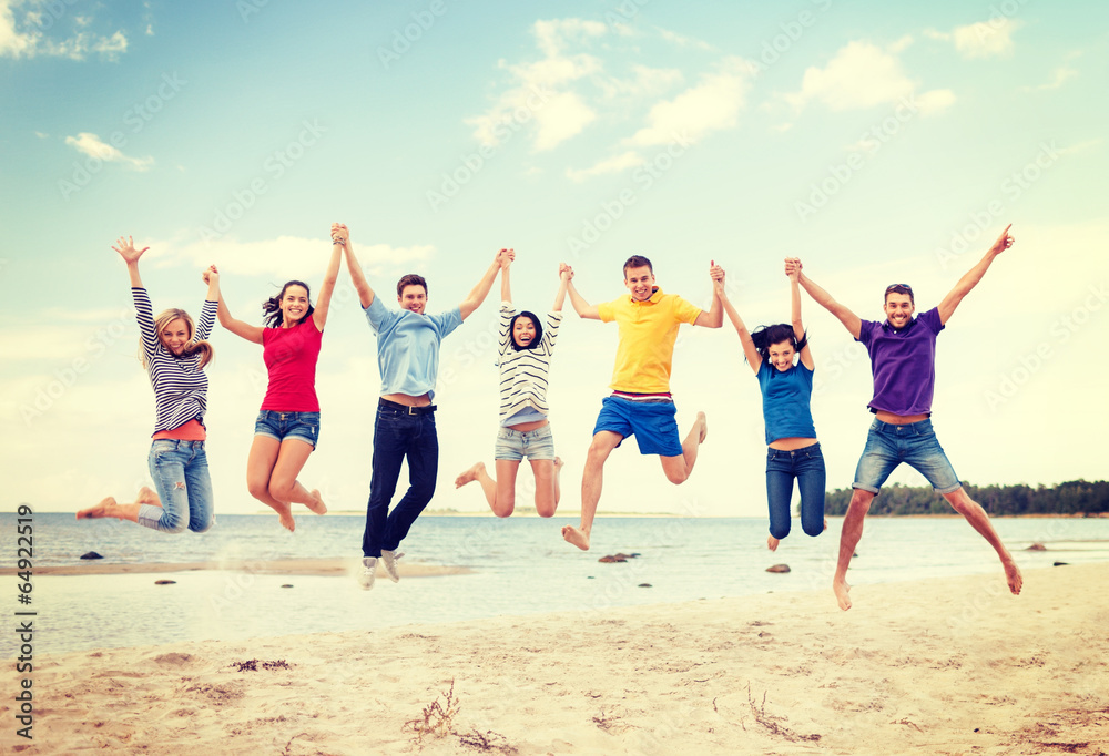 Fototapeta premium group of friends jumping on the beach