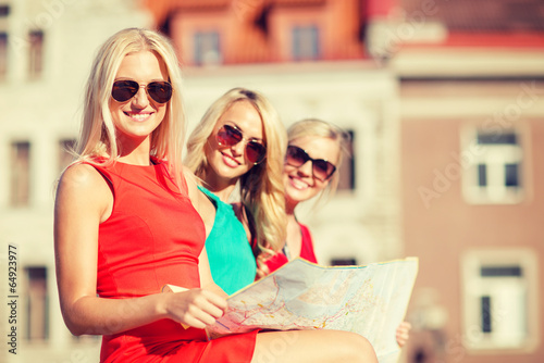 beautiful three women with tourist map in the city