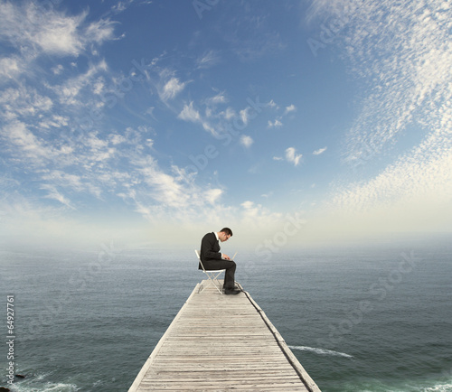 businessman sitting on pier
