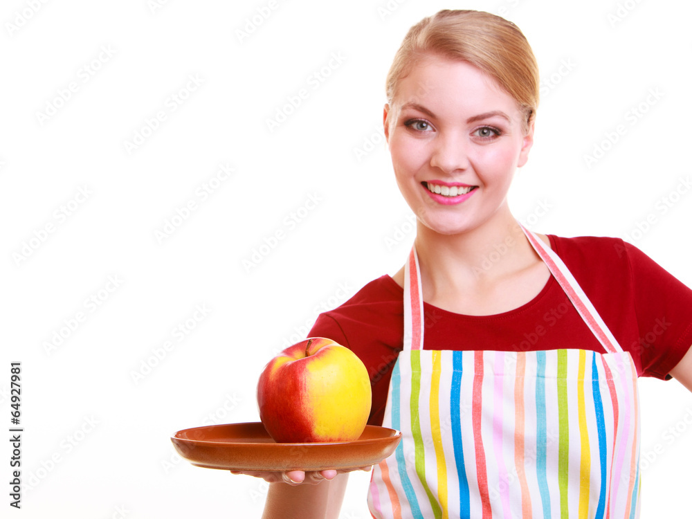Happy housewife or chef in kitchen apron showing apple isolated Happy housewife or chef in kitchen apron showing apple isolated