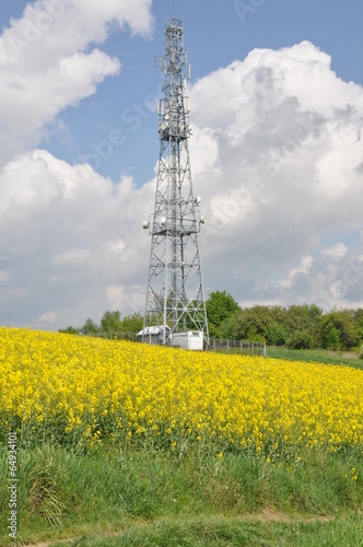 Telecommunication tower on the field against the sky photo