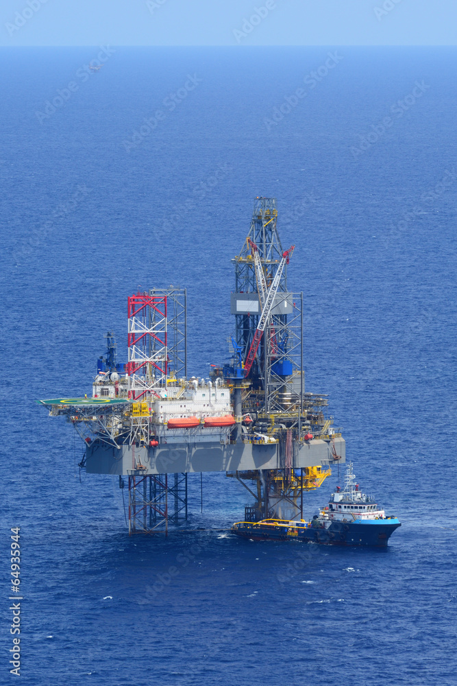 The offshore drilling oil rig and supply boat side view The offshore drilling oil rig and supply boat side view