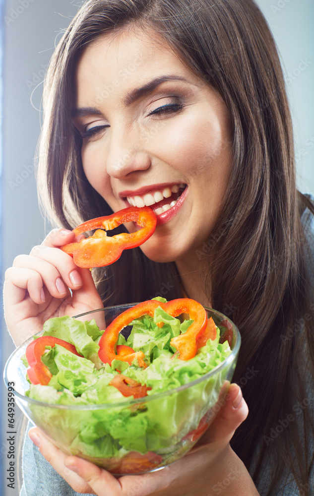 Woman eating green salad . Female model close up face studio is Woman eating green salad . Female model close up face studio is