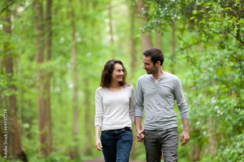 Obraz na plátně Young couple having a walk in a forest