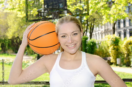 Sportliche Frau spielt Basketball