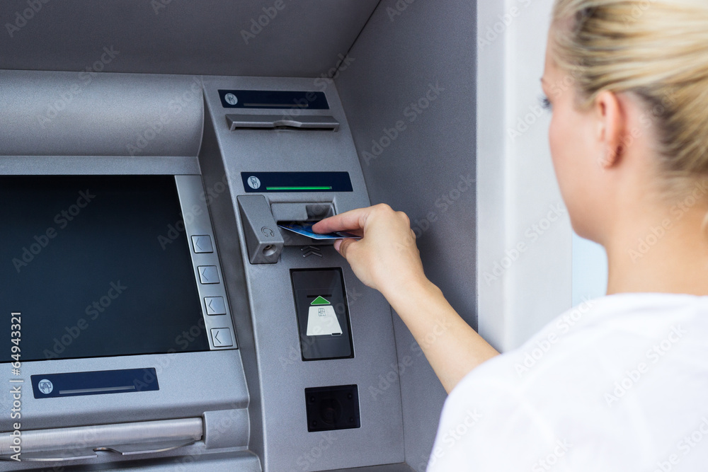 Businesswoman withdrawing money from credit card at ATM Businesswoman withdrawing money from credit card at ATM