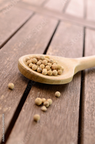 White pepper on a wooden spoon