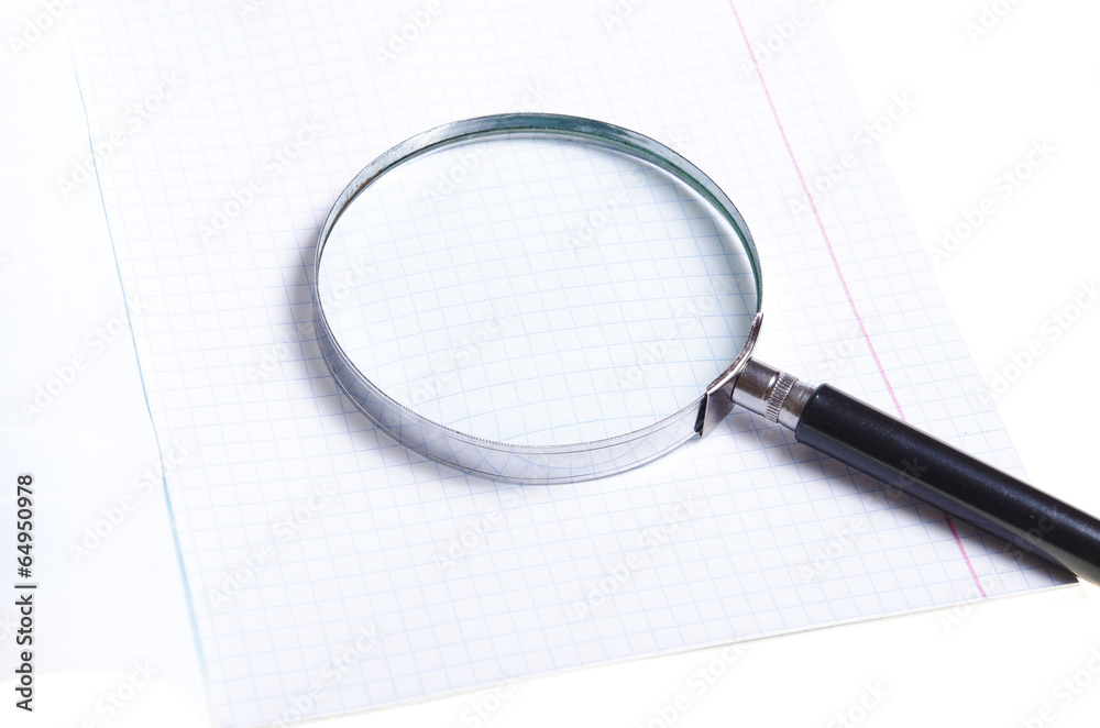 Magnifier on white notebook sheet Magnifier on white notebook sheet