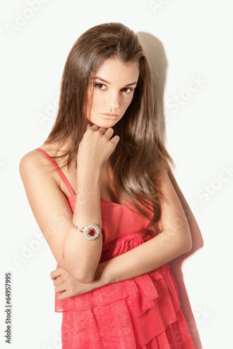 beautiful brunette woman model posing in red dress in the studio