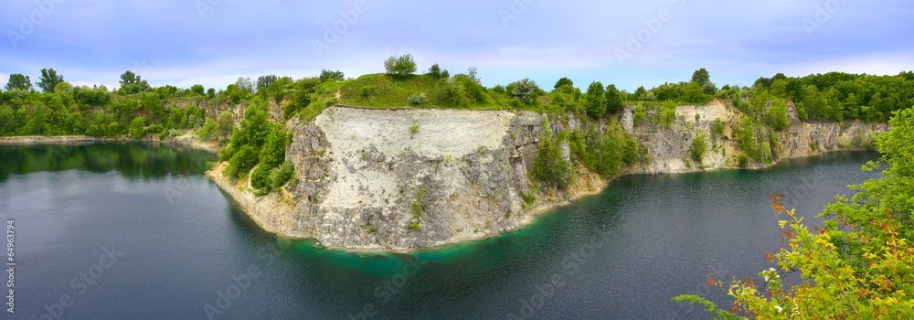 Skalisty brzeg jeziora po wykopaliskach kamieniołomu - obrazy, fototapety, plakaty 