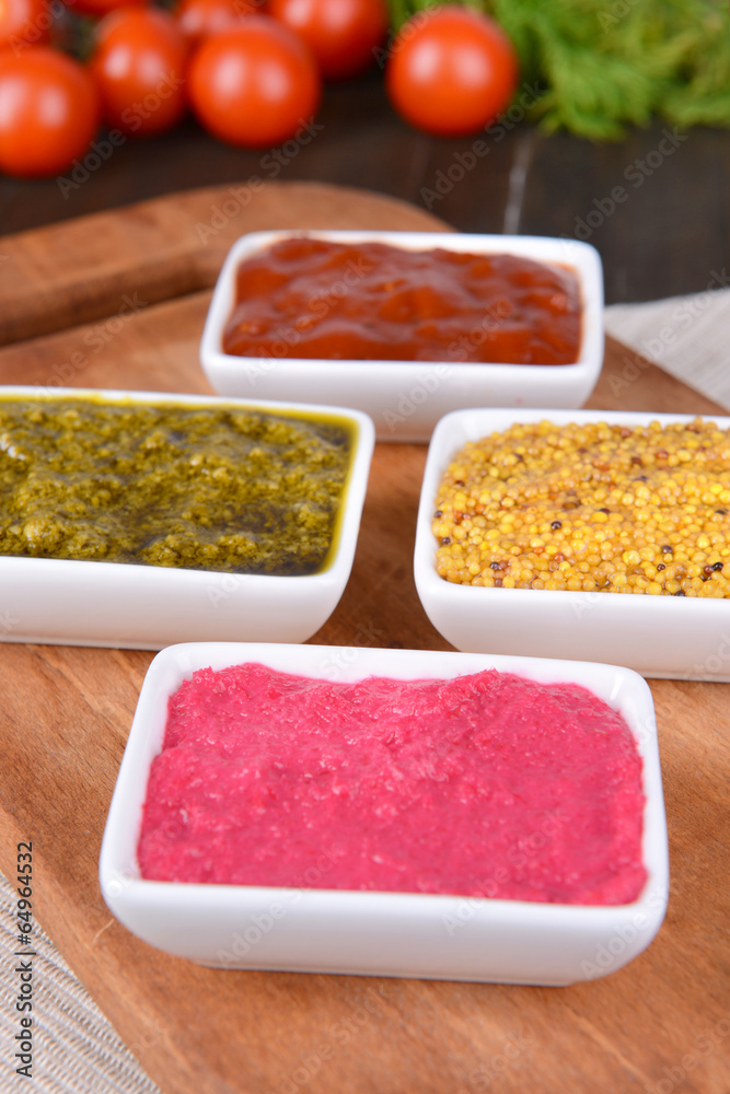 Various sauces on chopping board on table close-up