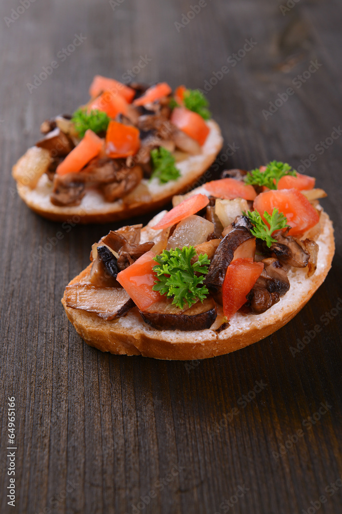 Delicious bruschetta with mushrooms on table close-up