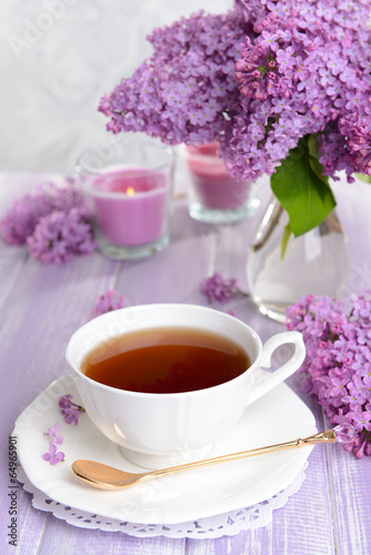 Beautiful lilac flowers with cup of tea