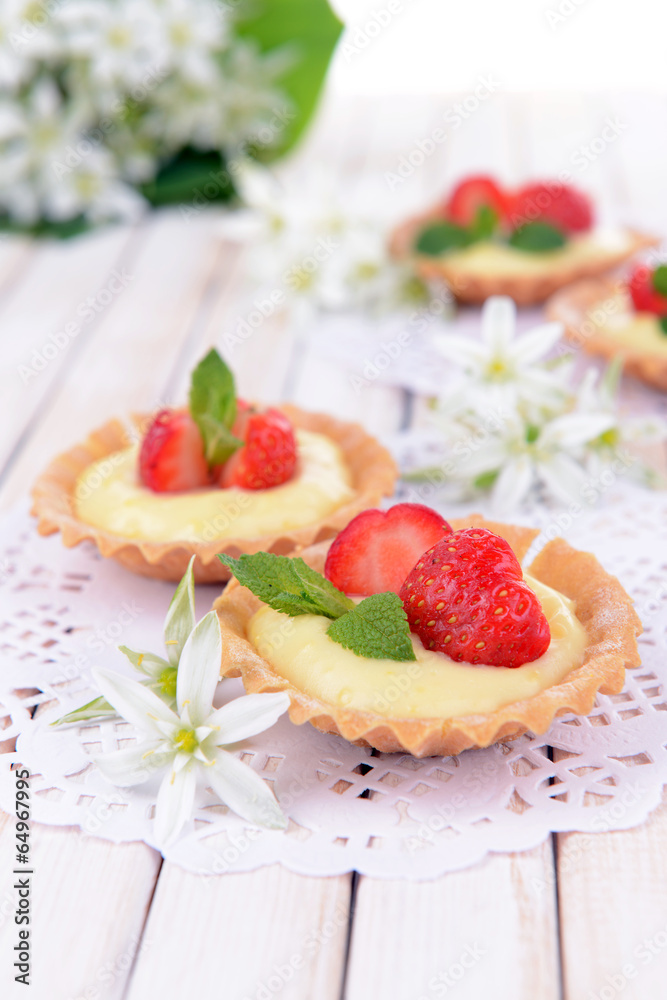 Tasty tartlets with strawberries on table close-up Tasty tartlets with strawberries on table close-up