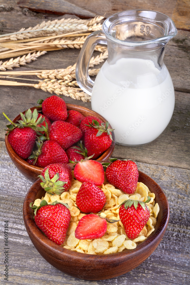 cornflakes in a wooden bowl with milk and strawberries cornflakes in a wooden bowl with milk and strawberries