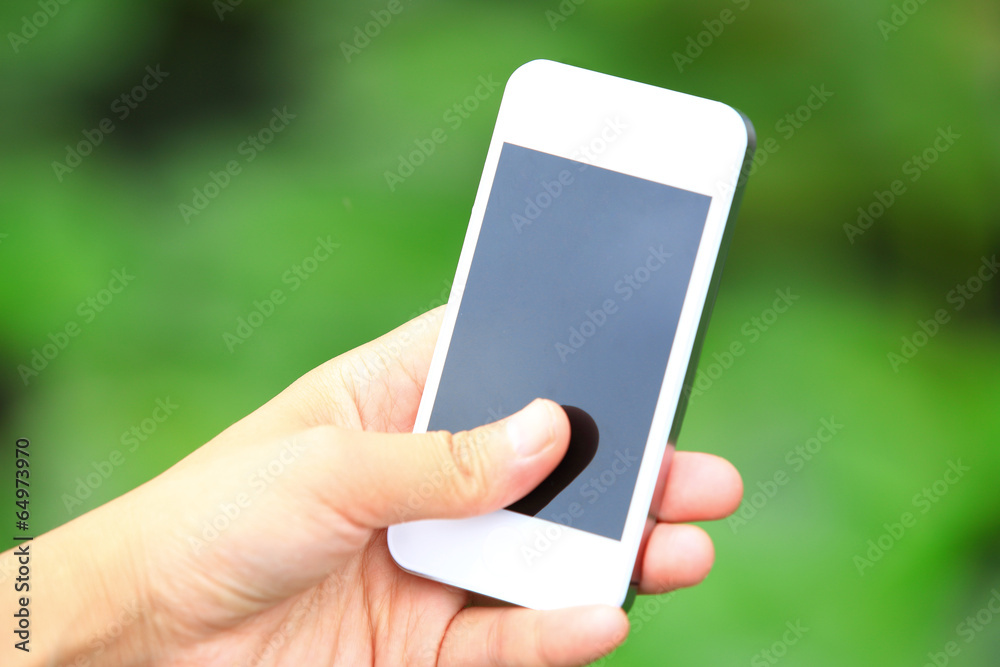 hands hold smart phone taking photo on green grass