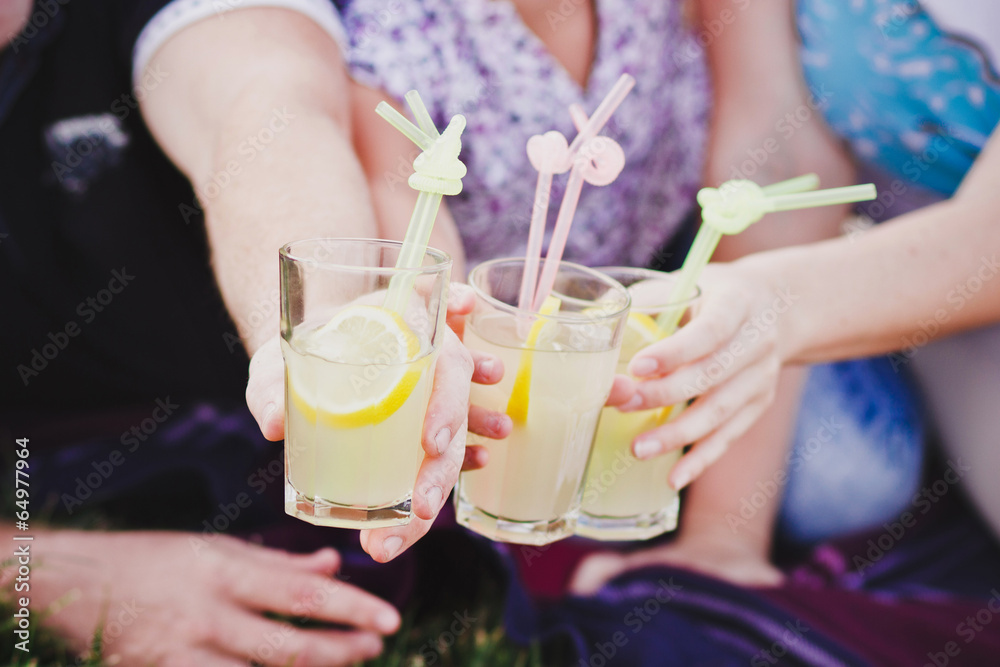 Three glasses of lemonade in people's hands Three glasses of lemonade in people's hands