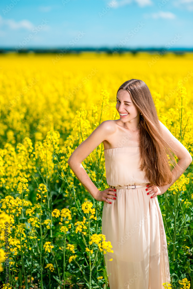 Beautiful happy girl standing on the colza field. Beautiful happy girl standing on the colza field.