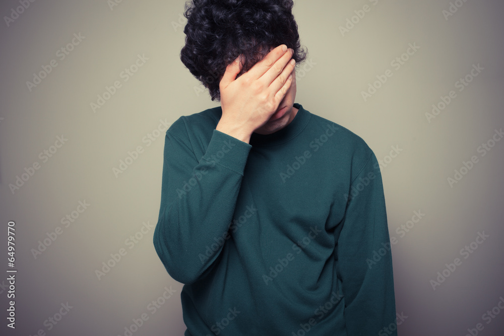 Fotografie Young man with his palms on his face