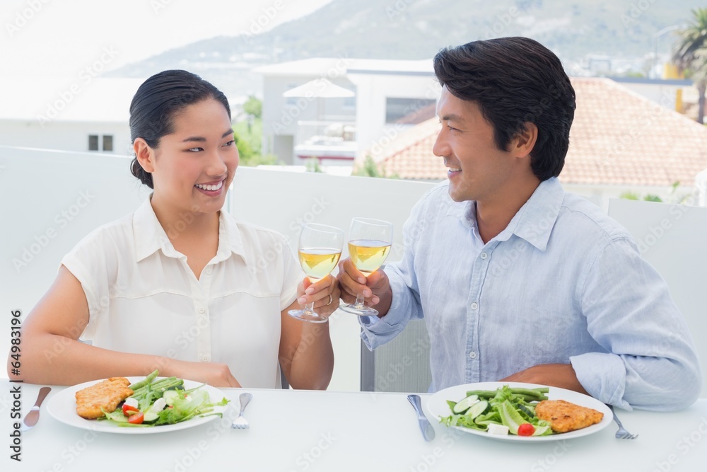 Happy couple having white wine with a meal