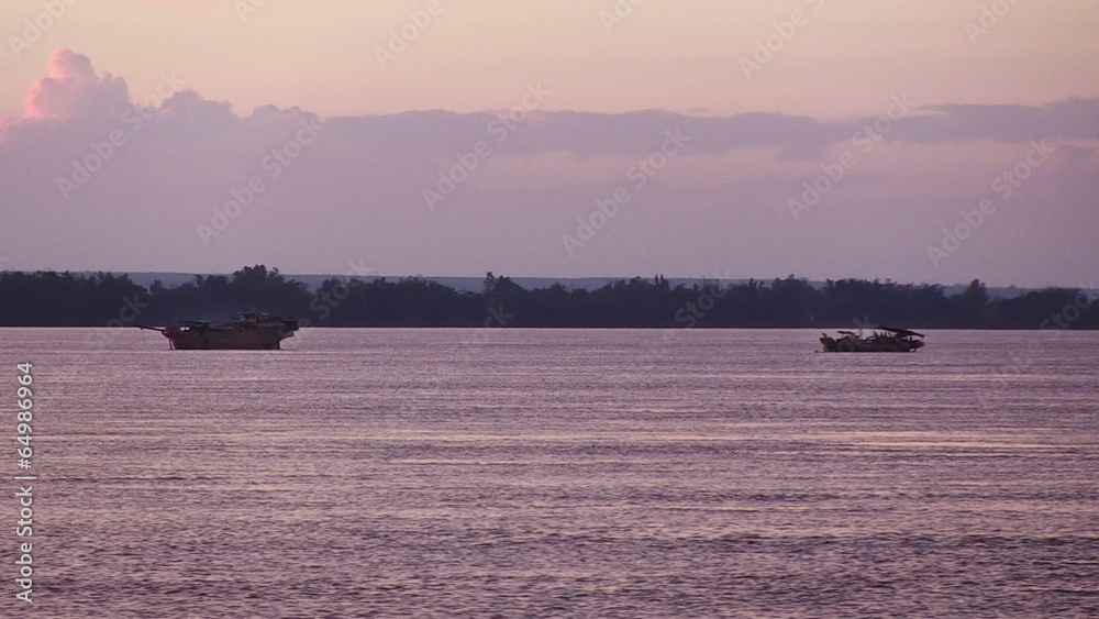 Dredging boats pumping riverbed sand under purple skies Dredging boats pumping riverbed sand under purple skies