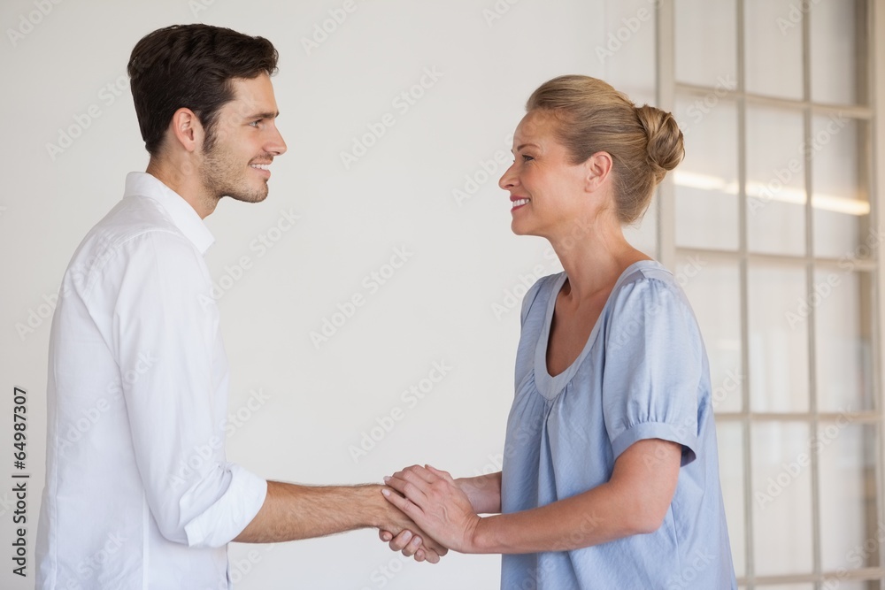 Fototapeta premium Casual business woman shaking hands with man