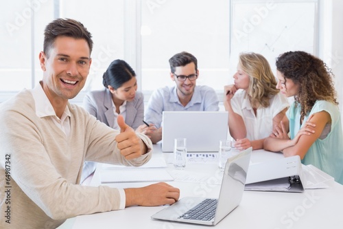 Casual business team having a meeting with man giving thumbs up