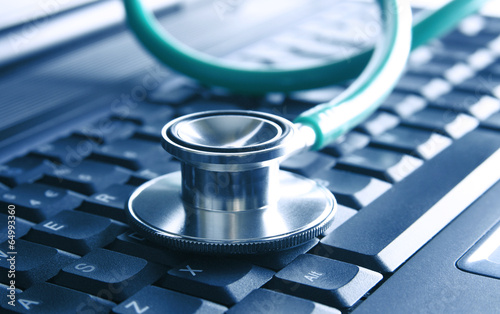 Obraz na płótnie Green stethoscope on notebook keyboard. Computer help w salonie