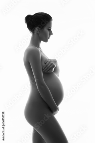 Naked pregnant woman with a beautiful belly on white