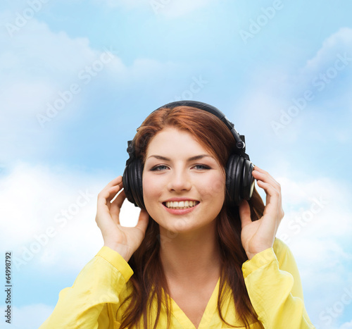 smiling young girl in headphones at home
