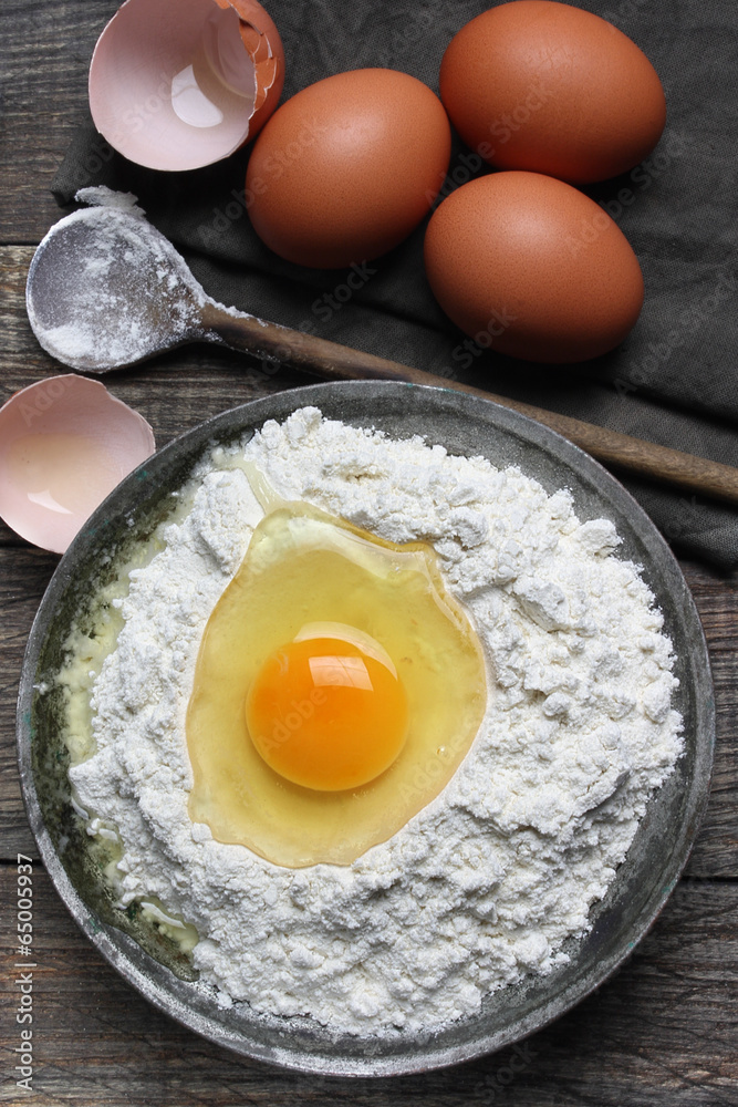 Wheat flour in metal bowl and eggs Wheat flour in metal bowl and eggs
