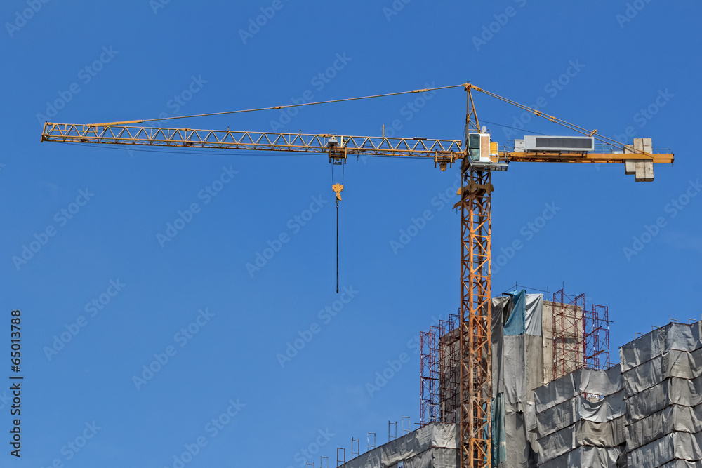 Yellow Construction Crane against Blue Sky Background