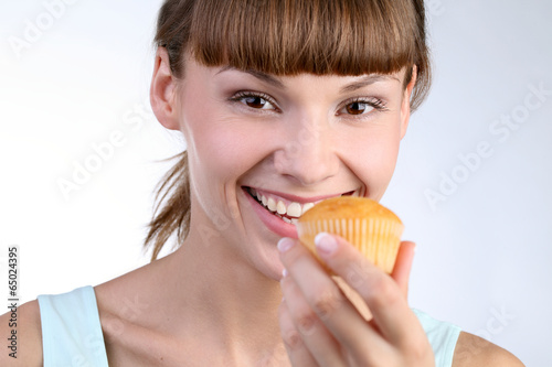 Молодая девушка с кексом в руке