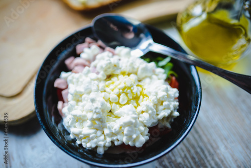 Przygotowanie sałatki z serka wiejskiego z pomidorem i szynką photo