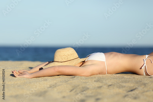 Woman resting sunbathing on the sand of the beach