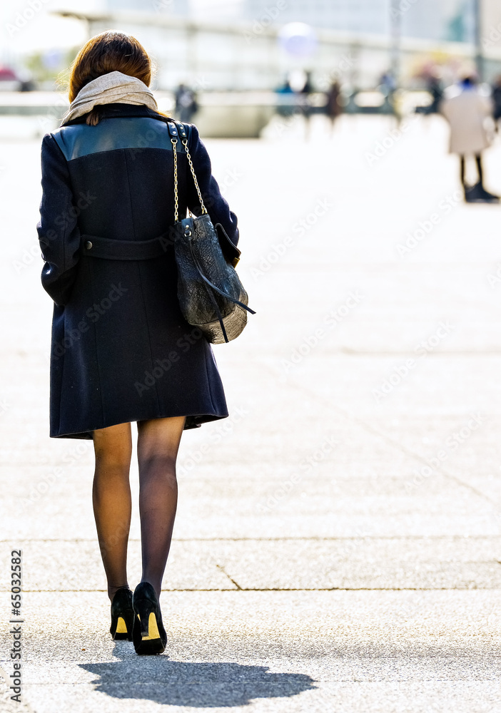 Young business woman walking on the city street Young business woman walking on the city street