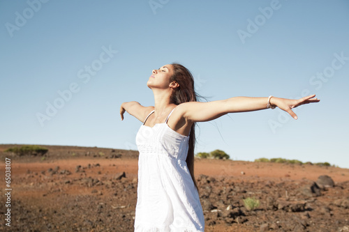 Woman with open arms in the nature