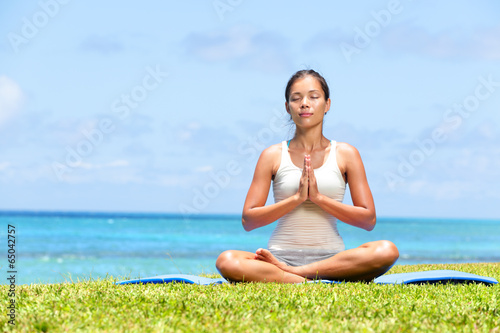 Meditation yoga woman on beach meditating by ocean