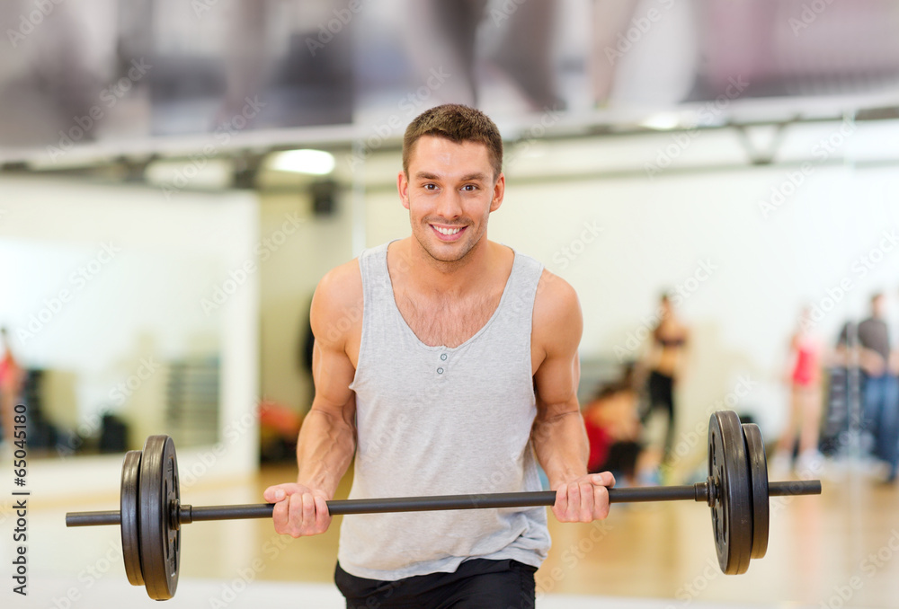 smiling man with barbell in gym smiling man with barbell in gym