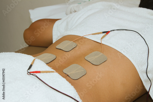 Patient  applying electrical stimulation therapy ( TENS ) on his