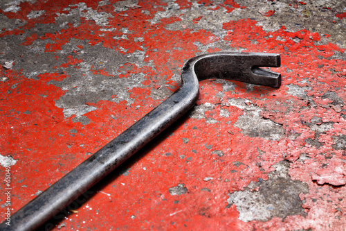 An old crowbar on a red background