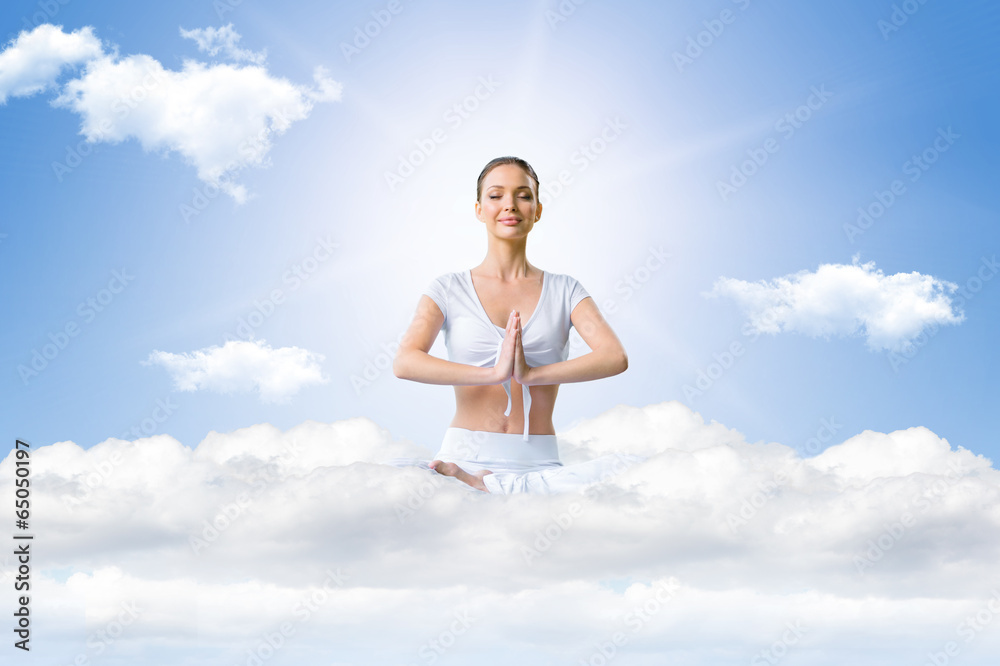 Young woman in a lotus position on the sky during meditation Young woman in a lotus position on the sky during meditation